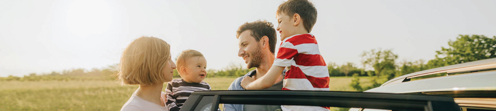 family outdoors beside car