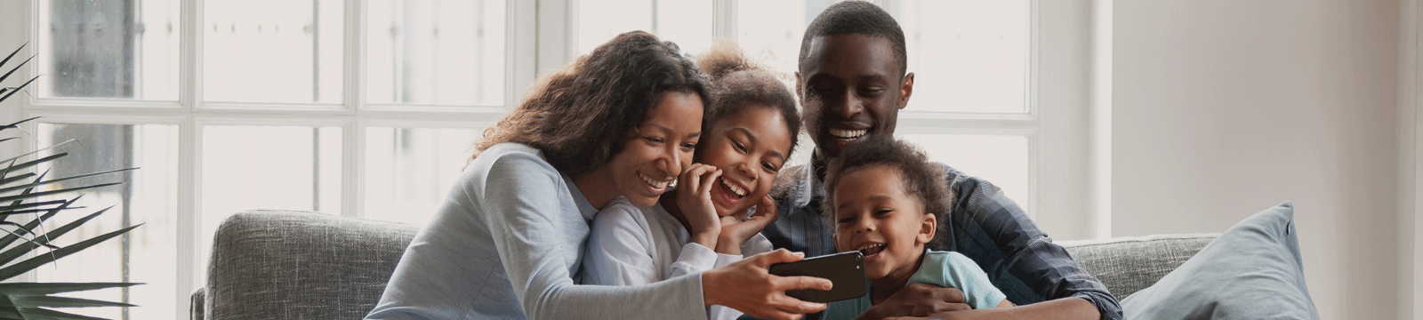 family looking at phone on the couch